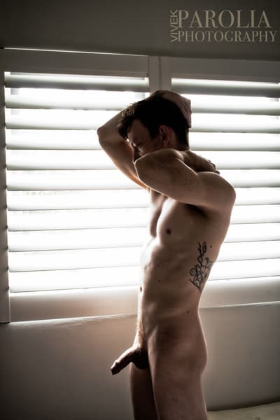 nude silhouette by the window. day light. nude artistic male portrait